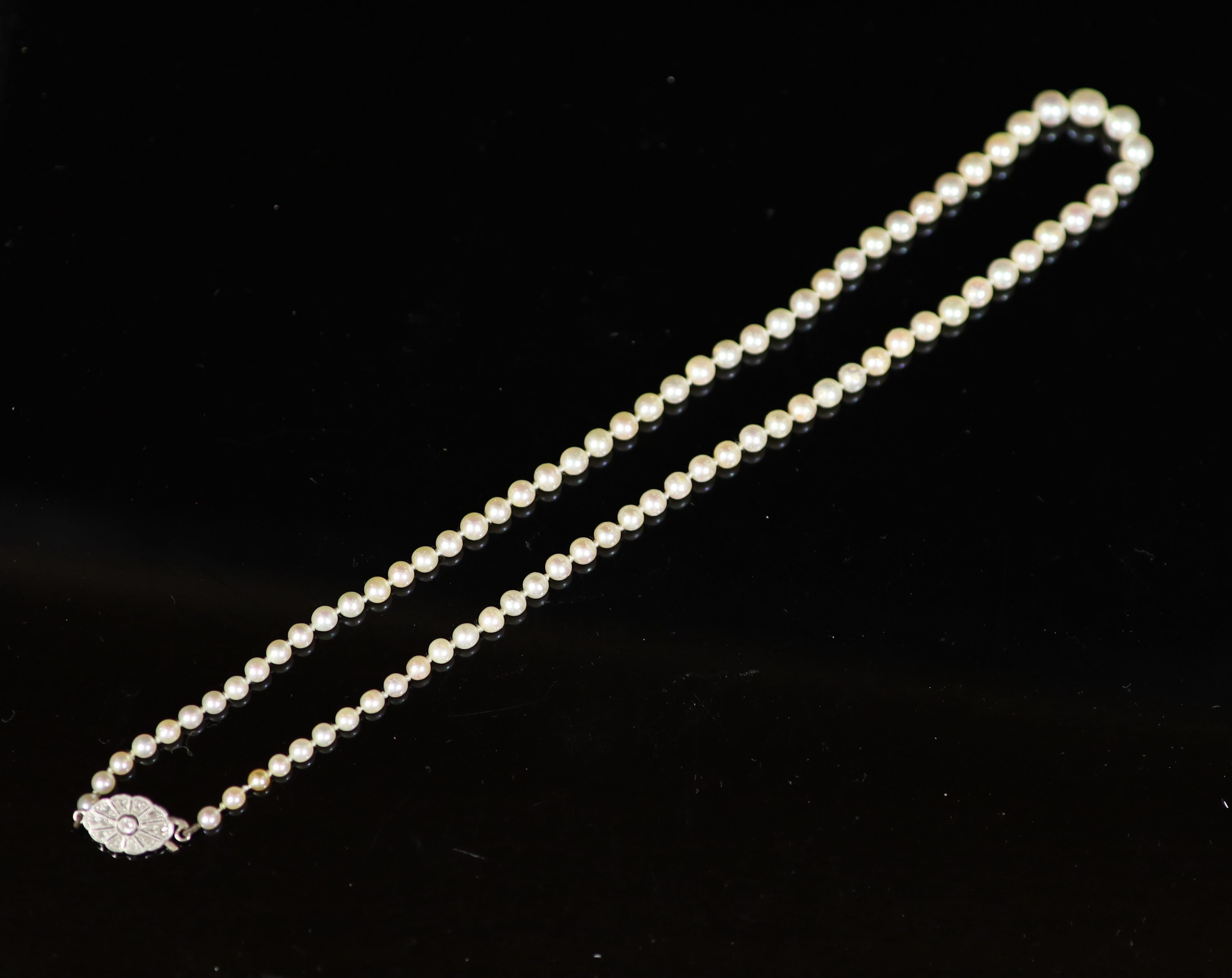 An early 20th century graduated pearl necklace, with platinum and millegrain set diamond clasp